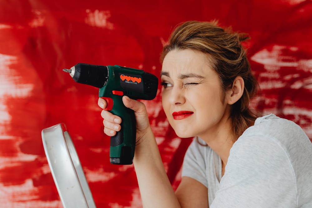 A woman holding a electric screwdriver